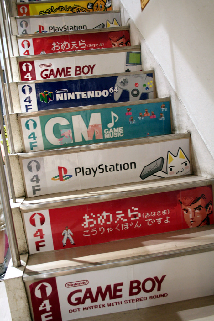 schody oklejone naklejkami reklamującymi gry na PS i nintendo, game boy i inne